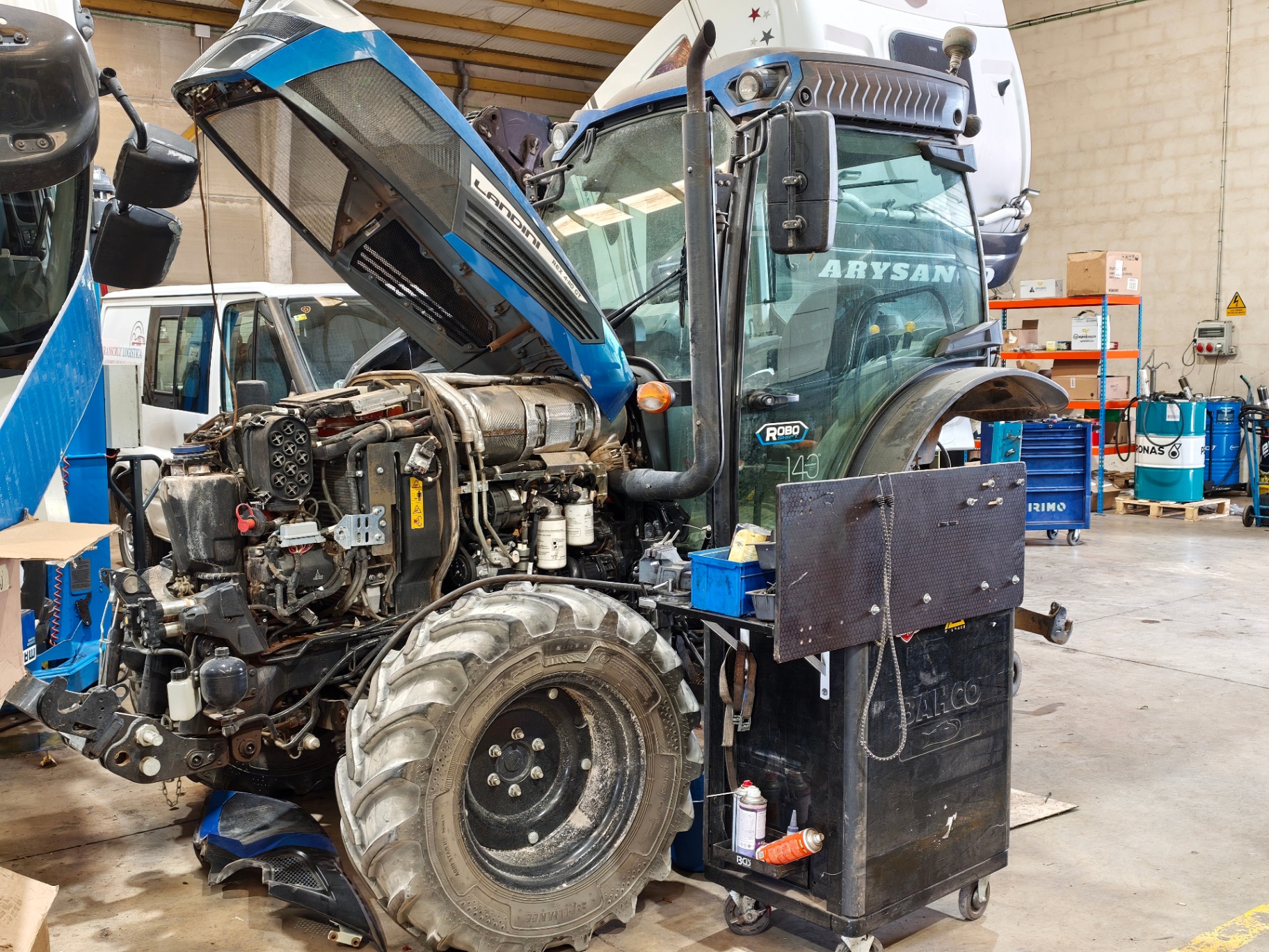 Tractor Landini azul con el motor abierto durante una reparación en el taller Izsetrack